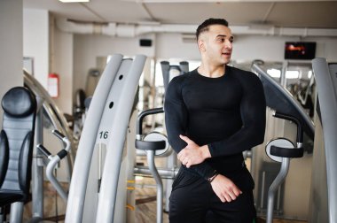 Modern spor salonunda spor yapan kaslı Arap adam spor yapıyor..