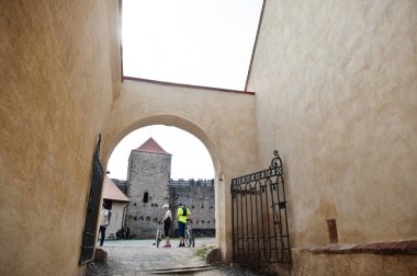 Brno, Çek Cumhuriyeti - 30 Nisan 2022: Çek Cumhuriyeti 'nin Veveri şatosunda bisiklet süren insanlar.