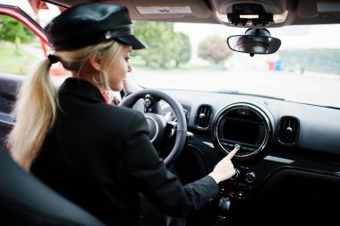 Şapkalı, siyah makyajlı, güzel, sarışın, seksi bir kadın modelin portresi. Kırmızı şehir arabasıyla otur ve sür.. 