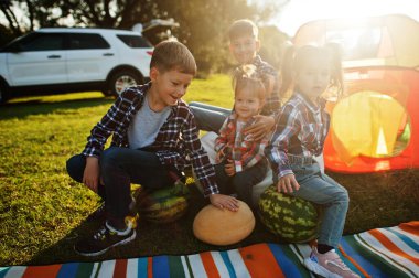 Dört çocuk birlikte vakit geçiriyor. Açık hava piknik battaniyesi, karpuz ile oturmak..