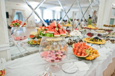 Beautiful wedding candy bar with sweets, fruits and food. Wedding banquet table