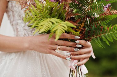 Bride holding beautiful tender wedding bouquet. Nails.