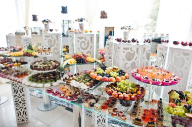Beautiful wedding candy bar with sweets, fruits and food. Wedding banquet table