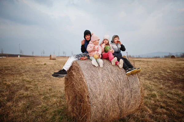 Τέσσερα Παιδιά Φρούτα Στα Χέρια Κάθονται Στα Άχυρα Στο Χωράφι — Φωτογραφία Αρχείου