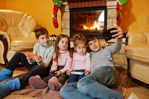 Щасливі Четверо Дітей Гаджетами Роблять Селфі Фото Вдома Біля Каміна — стокове фото