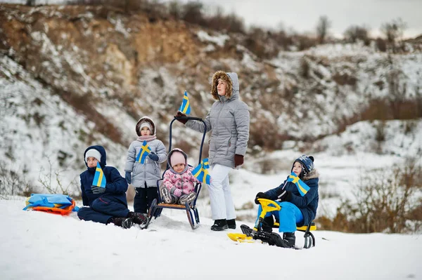 Scandinavian family with Sweden flag in winter swedish landscape.