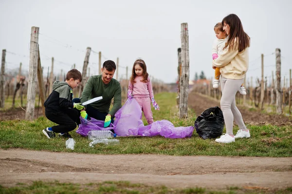 Keluarga Dengan Kantong Sampah Mengumpulkan Sampah Sambil Membersihkan Kebun Anggur — Stok Foto