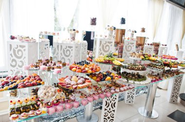 Beautiful wedding candy bar with sweets, fruits and food. Wedding banquet table