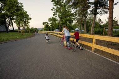 Brno, Çek Cumhuriyeti - 21 Mayıs 2022: Üç çocuklu anne pedalsız bisiklete biniyor.
