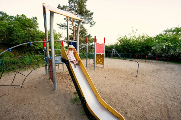公園に設置された子供の遊び場のおもちゃで赤ちゃんの女の子のスライド — ストック写真