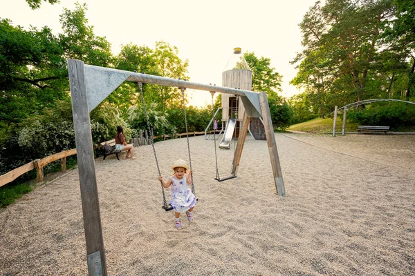 公園に設置された子供の遊び場のおもちゃで赤ちゃんの女の子スイング — ストック写真