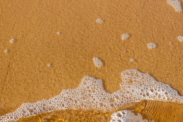 国の輪郭を形成する泡と透明な海水 水の下にはバルト海の黄金の砂 世界に関する何世紀も前の情報を運ぶ素晴らしい石の粒があります — ストック写真