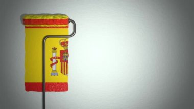 Roller paints the wall in colors of Spain flag.  Travel concept.