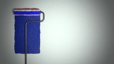 Roller paints the wall in colors of French flag.  Travel concept. France.