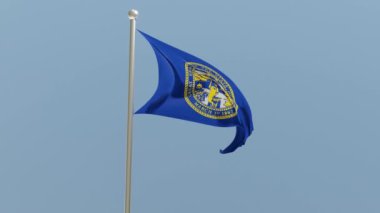 Nebraska flag on flagpole. NE flag fluttering in the wind. USA. National flag.