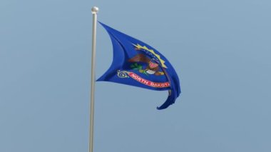 North Dakota flag on flagpole. ND flag fluttering in the wind. USA. National flag.