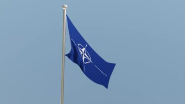 Nato army flag on flagpole. Military organization flag fluttering in the wind.