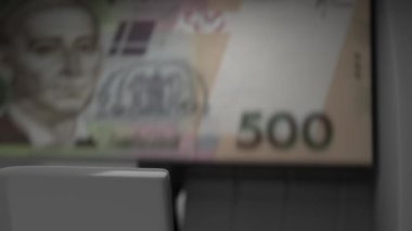 500 Ukrainian hryvnia in cash dispenser. Withdrawal of cash from an ATM. Financial transaction in the bank terminal. UAH.