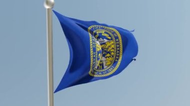 Nebraska flag on flagpole. NE flag fluttering in the wind. USA.