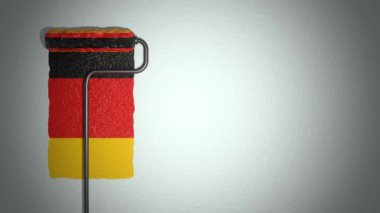 Roller paints the wall in colors of German flag. Travel concept.