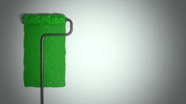 Roller paints the wall with green paint. Renovation concept.