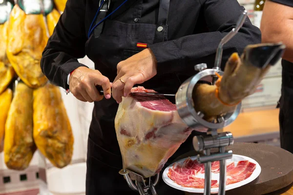 Serrano jambonu kesen kadın uzmanın fotoğrafı..