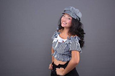 Güzel ve gülümseyen, şapkalı ve çizgili genç Çinli kız.