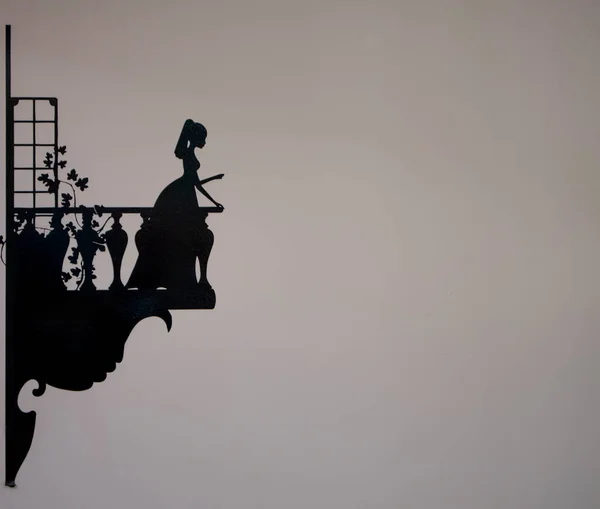 Balkondan sarkan genç bir kızın siluetinin fotoğrafı.