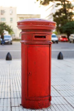 Caddedeki eski kırmızı posta kutusunun yakın plan fotoğrafı.
