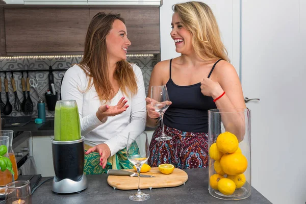 cute vegan lesbian couple, preparing spinach smoothie. LGTB concept, vegan people