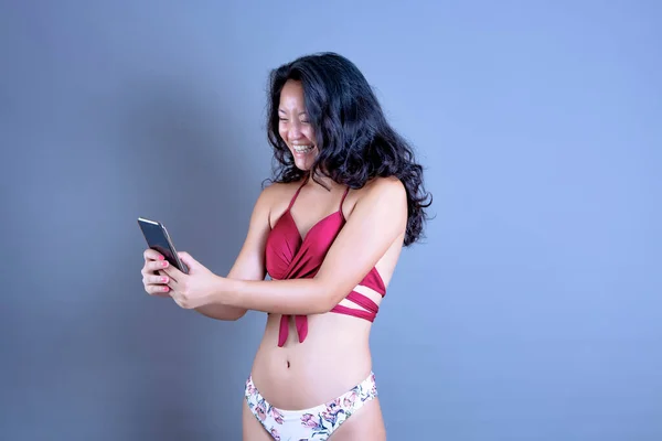 Κινέζα Γυναίκα Μπικίνι Κοιτάζει Έξυπνο Τηλέφωνο Χαρούμενο Και Αστείο — Φωτογραφία Αρχείου