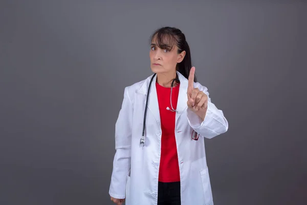 photo of attractive female doctor with angry expression scolding