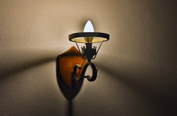 photo of old interior wall sconce with light bulb and cobwebs