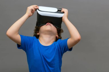 curly-haired caucasian boy wearing virtual reality glasses