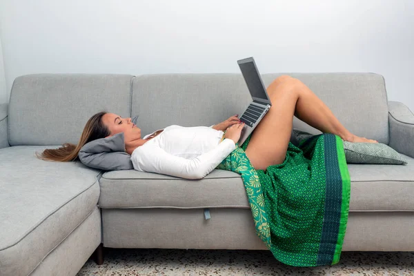 Młoda Kobieta Leżąca Kanapie Laptopem — Zdjęcie stockowe