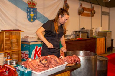 Alicante İspanya 23-09-2022 Akdeniz gastronomi fuarı Galiçya yemek standında tipik bir ahtapotu hazırlayan bir kadınla.