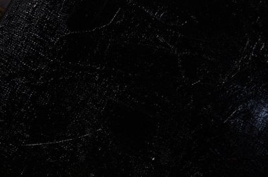 Karanlık yaratıcı arka plan, pürüzlü keten branda siyah astar ile örtülü, ışığın yansımaları. Tonlama, bulanıklaştırma, seçici odaklanma. 