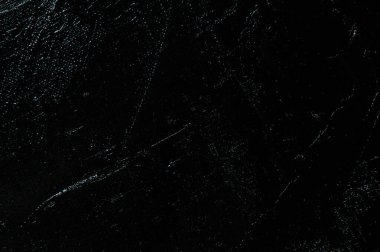 Karanlık yaratıcı arka plan, pürüzlü keten branda siyah astar ile örtülü, ışığın yansımaları. Tonlama, bulanıklaştırma, seçici odaklanma. 