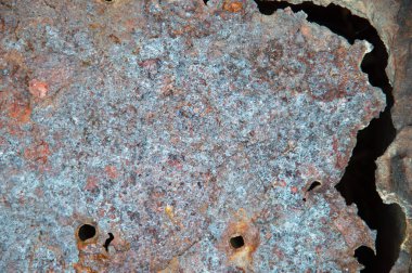 Grunge arkaplan: eski boyanmış metal bir yüzeyde pas, çelik korozyonundan kaynaklanan delikler, tonlama 