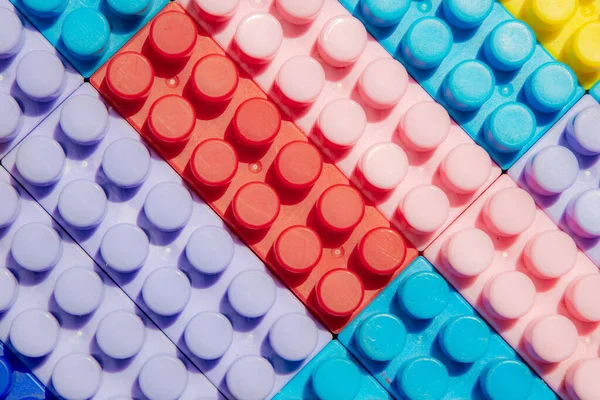 Çocuk oyun arka planı: Plastik çok renkli tuğlalar, bulanık, seçici odak düzlemi 