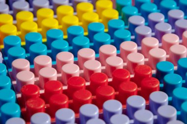 Çocuk oyun arka planı: Plastik çok renkli tuğlalar, bulanık, seçici odak düzlemi 