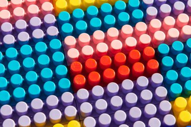 Çocuk oyun arka planı: Plastik çok renkli tuğlalar, bulanık, seçici odak düzlemi 