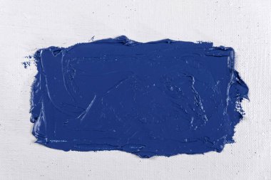 Beyaz, sanatsal bir gazlı bez üzerinde geniş bir mavi boya darbesi yakın çekim, tonlama, serbest alan 