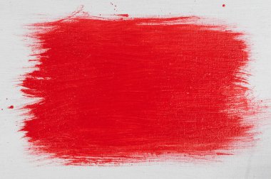 düz bir yüzey üzerinde düz olmayan bir yamaya uygulanan kırmızı akrilik boya. 