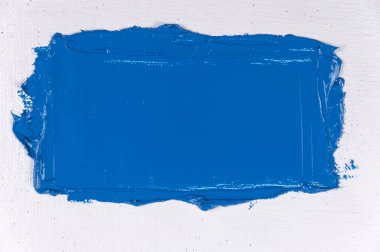 Beyaz, sanatsal bir gazlı bez üzerinde geniş bir mavi boya darbesi yakın çekim, tonlama, serbest alan 