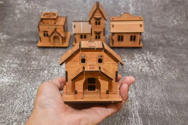 Diğer bulanık ev modellerinin arka planında ev modelini tutmak. Seçici odak resmi.