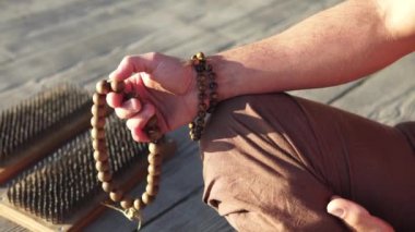 Sakallı adam gün doğumunda yoga yapıyor. 