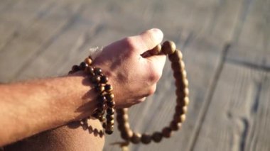 Sakallı adam gün doğumunda yoga yapıyor. 