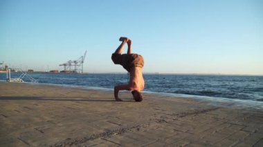 Sakallı adam gün doğumunda yoga yapıyor. 