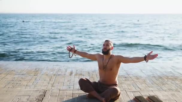 Sakallı adam gün doğumunda yoga yapıyor. — Stok video